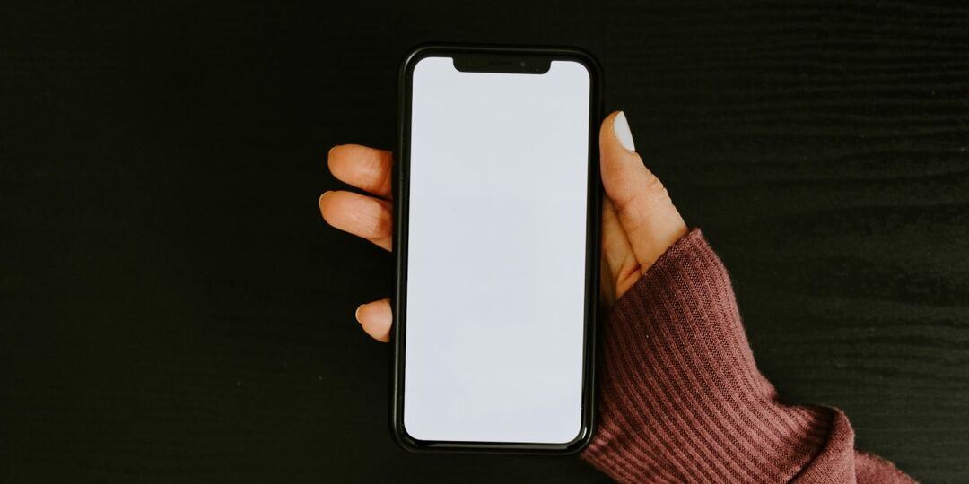 Fotografie osoby držící svůj iPhone