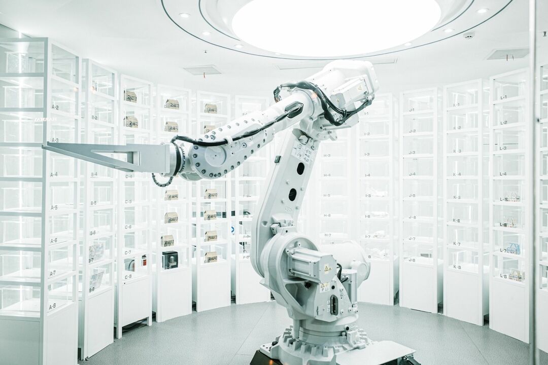 Futuristinis, ryškiai apšviestas baltas kambarys su robotu mašina