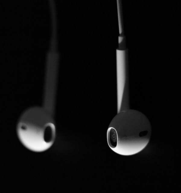 Fotograafia kahest Apple'i kõrvaklappidest, mis rippuvad allapoole ja mille üks külg on fookusest väljas