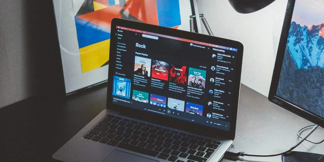 fotografie macbooku na stole s otevřeným spotify