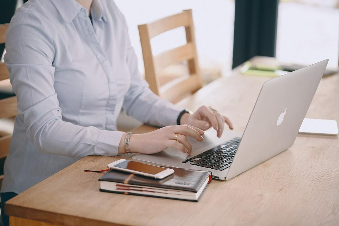 foto seorang wanita yang sedang mengerjakan macbook