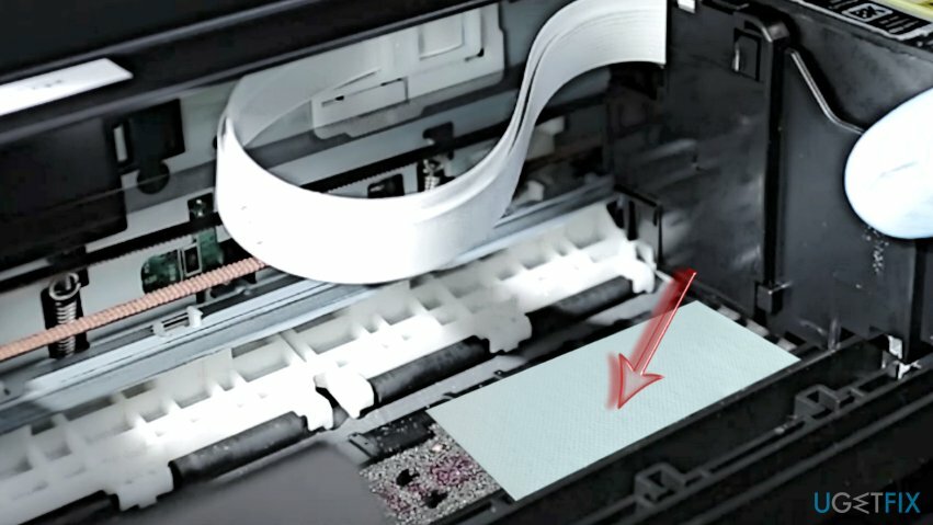 ضع المنشفة الورقية المطوية مع محلول التنظيف أسفل رأس الطباعة