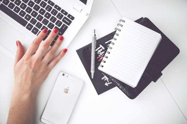 vrouw-hand-smartphone-bureau