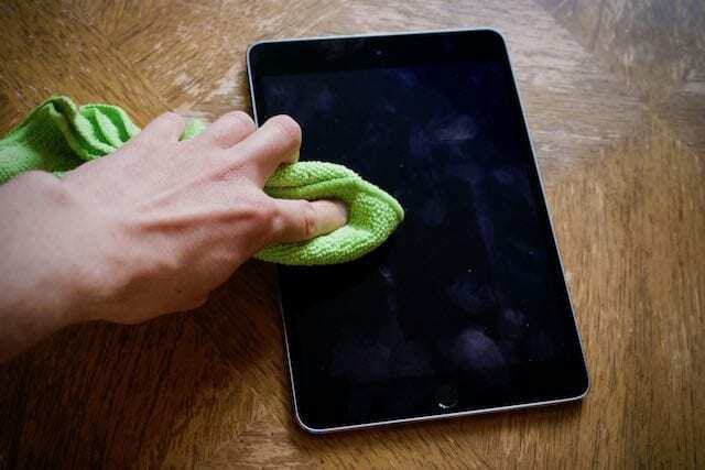 Nettoyer un écran d'iPad sale avec un chiffon en microfibre.