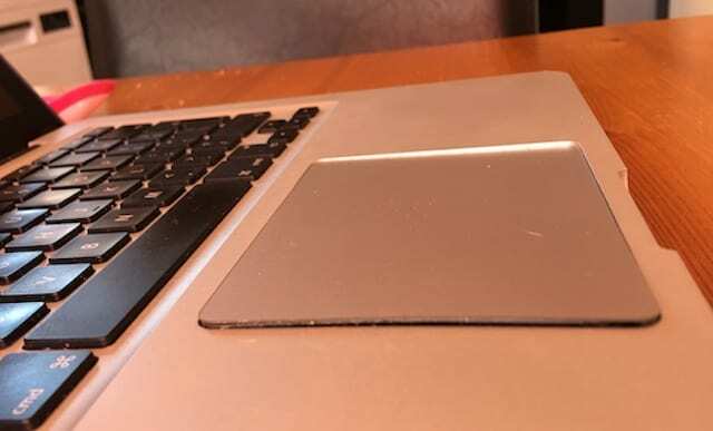 MacBook dengan trackpad yang dinaikkan atau diangkat.