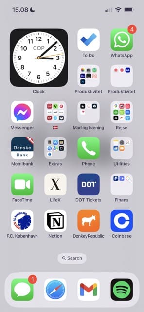 Екранна снимка, показваща началния екран на iPhone с изтеглен iOS 16