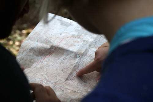 ადამიანის ფოტო, რომელიც ამოწმებს ქაღალდის რუკას