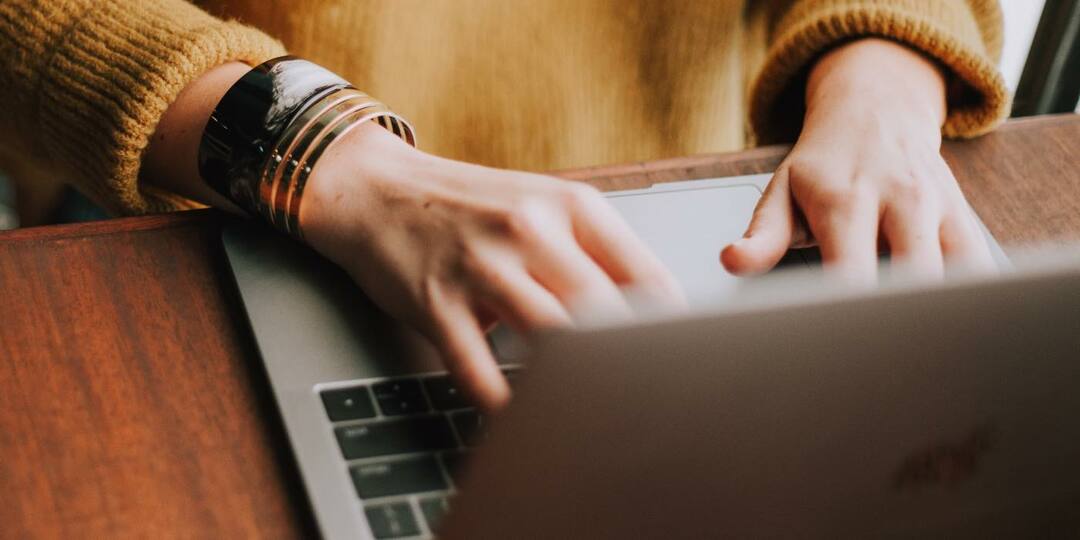 Foto de una persona escribiendo en el teclado de su MacBook