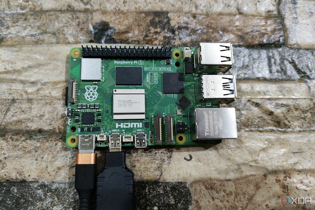 Raspberry Pi 5 su USB Type-C įkrovimo laidu ir prijungtu micro HDMI į HDMI adapteriu