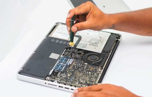 Apple tehničar popravlja MacBook trackpad koji ne škljoca.