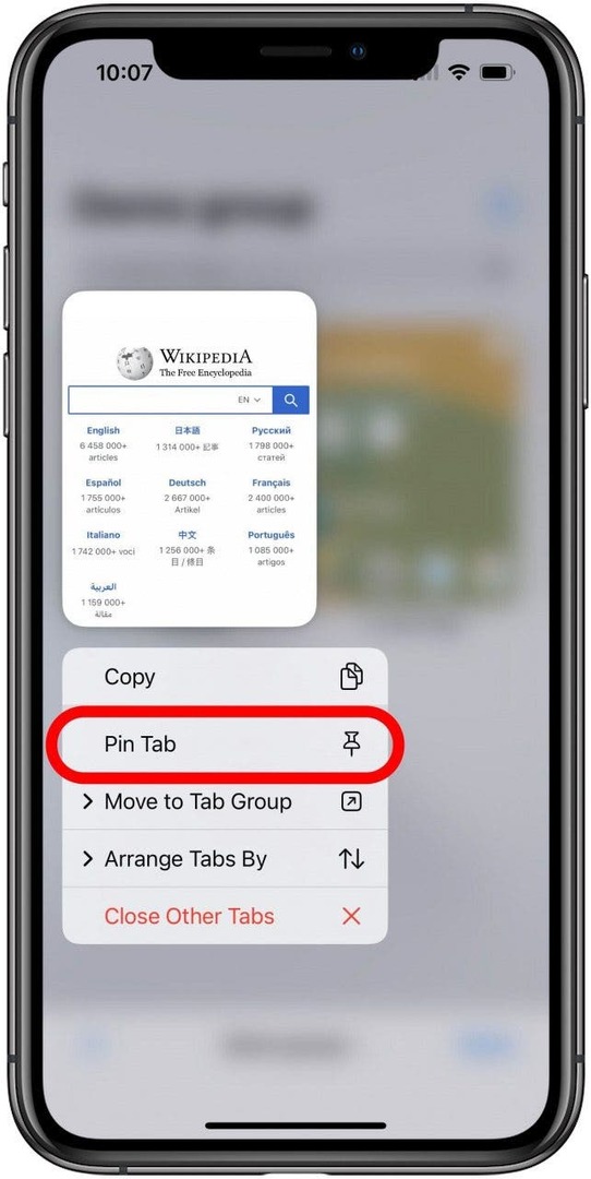 تطبيق Safari مع شاشة علامات التبويب لمجموعة Tab Group غير واضحة في الخلفية وعلامة تبويب واحدة مرئية مع فتح قائمة الضغط لفترة طويلة أسفلها. يتم وضع علامة على خيار Pin Tab في القائمة.