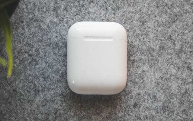 Nabíjacie puzdro AirPods uzavreté na sivom povrchu