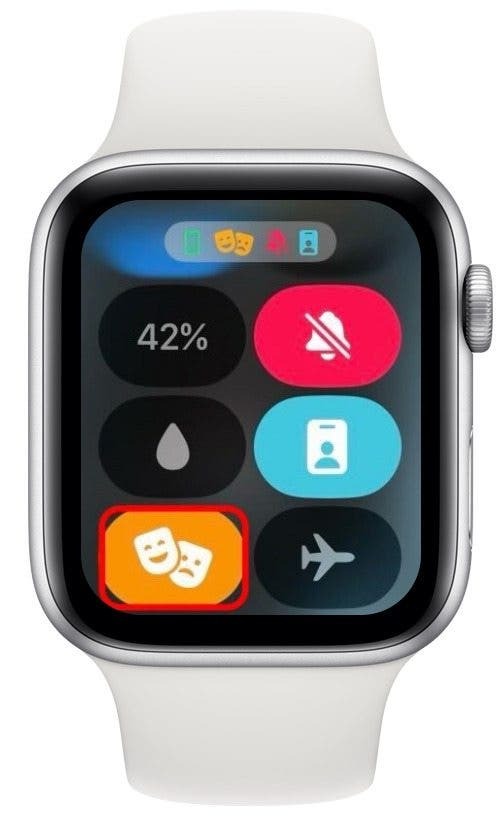 Centrul de control Apple Watch cu pictograma mod teatru (pictogramă portocalie cu două măști de teatru) încercuită cu roșu